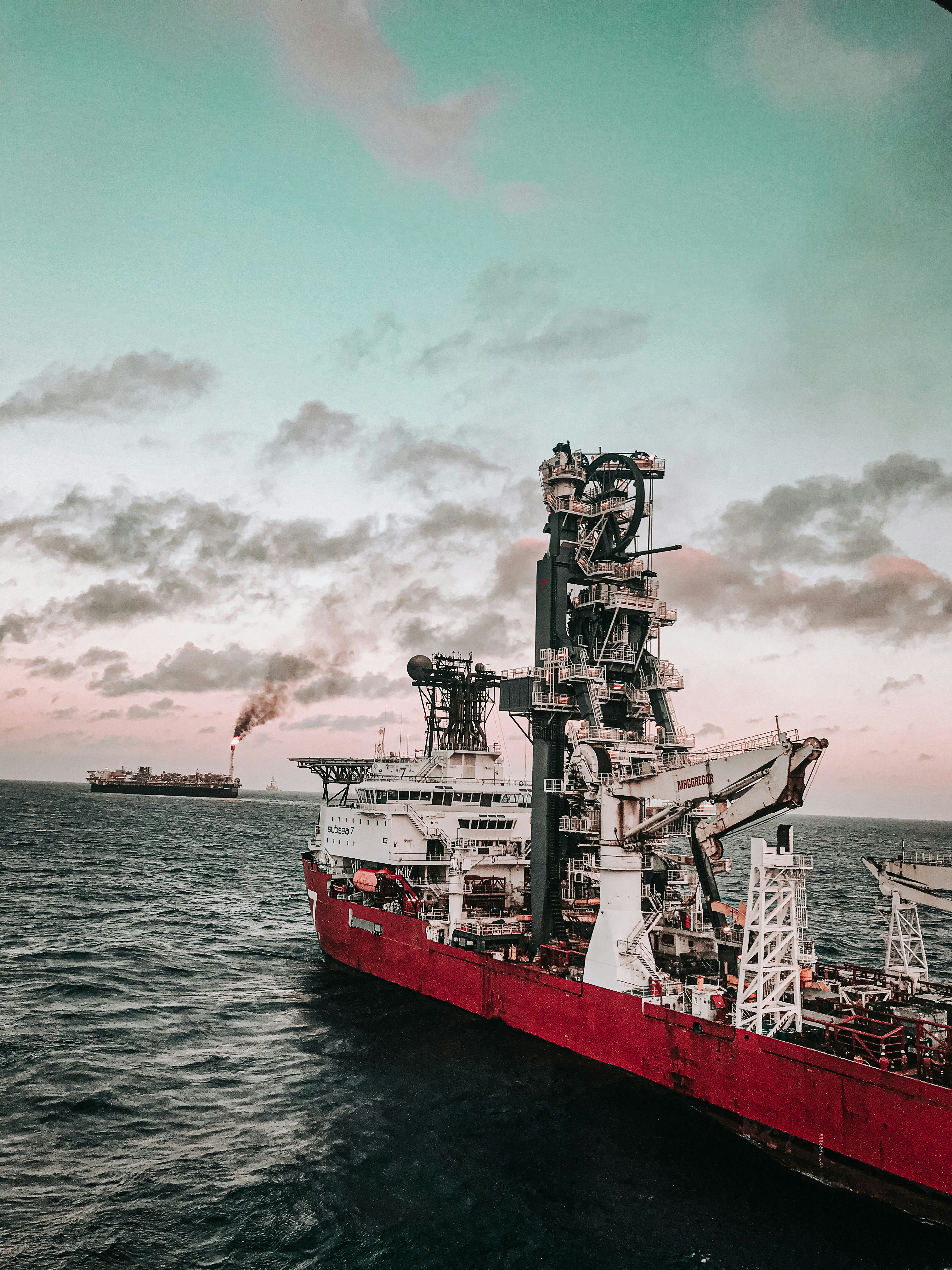 Offshore drillship at dusk with dramatic sky.